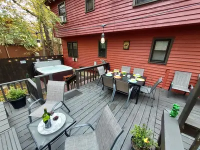 an outdoor deck with a table and chairs and a grill at Chalet renovated Near Casino, Camelback , Kalahari 4bdrms firepit hot tub game room in Tobyhanna