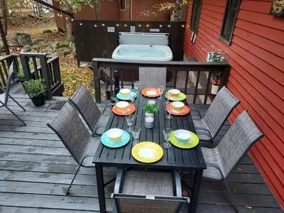 a wooden table with plates of food on a patio at Chalet renovated Near Casino, Camelback , Kalahari 4bdrms firepit hot tub game room in Tobyhanna