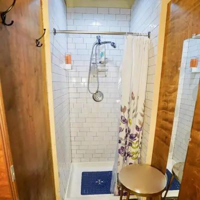 a small bathroom with a shower and a stool at Interfaith Retreats in New York