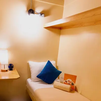 a room with a bed with a blue pillow and a book at Interfaith Retreats in New York