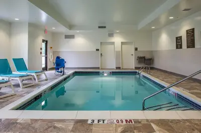 a swimming pool with a person in a wheelchair in a building at Comfort Inn PA Turnpike - I-81 in Carlisle