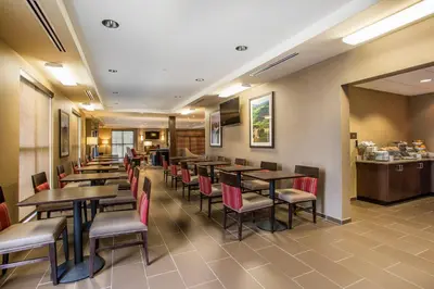 a restaurant with tables and chairs and a counter at Comfort Inn PA Turnpike - I-81 in Carlisle