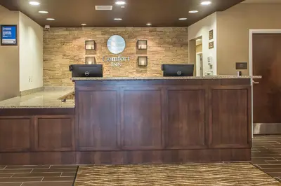 a lobby with a counter with two laptops on it at Comfort Inn PA Turnpike - I-81 in Carlisle