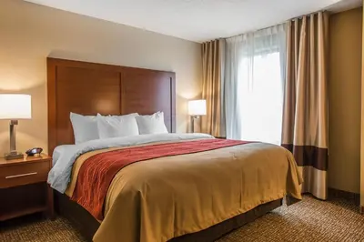 a hotel room with a bed with a large window at Comfort Inn PA Turnpike - I-81 in Carlisle