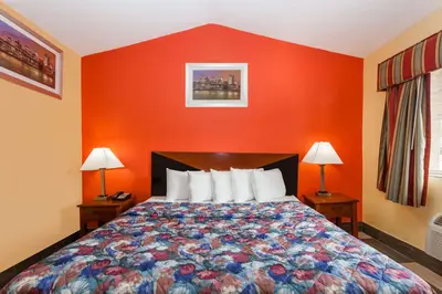 a bedroom with a bed with an orange wall at Travelodge by Wyndham Jersey City in Jersey City