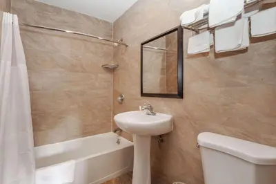 a bathroom with a sink and a toilet and a tub at Travelodge by Wyndham Jersey City in Jersey City