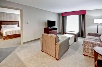 a hotel room with a bed and a living room at Homewood Suites by Hilton Bridgewater/Branchburg in Branchburg Park