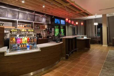 a bar in a restaurant with a lot of drinks at Courtyard by Marriott Elmira Horseheads in Horseheads