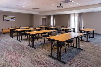 an empty classroom with wooden tables and chairs at Courtyard by Marriott Elmira Horseheads in Horseheads