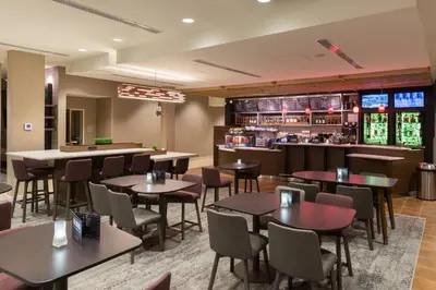 a restaurant with tables and chairs and a bar at Courtyard by Marriott Elmira Horseheads in Horseheads