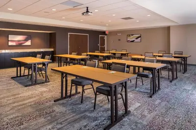 a classroom with wooden tables and chairs in a room at Courtyard by Marriott Elmira Horseheads in Horseheads