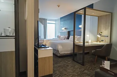 a hotel room with a bed and a desk and a mirror at SpringHill Suites by Marriott Somerset Franklin Township in Somerset