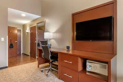 a room with a desk with a tv and a chair at Comfort Suites Manheim - Lancaster in Manheim