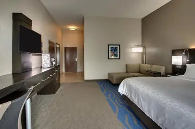 a hotel room with a bed and a couch at Holiday Inn Express & Suites Lancaster East - Strasburg by IHG in Strasburg