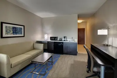 a living room with a couch and a desk in a hotel room at Holiday Inn Express & Suites Lancaster East - Strasburg by IHG in Strasburg