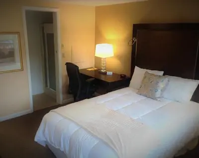 a bedroom with a bed and a desk with a lamp at Wayne Inn in Honesdale