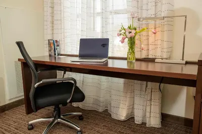 a desk with a laptop and a vase of flowers on it at Residence Inn by Marriott Philadelphia Great Valley/Malvern in Malvern
