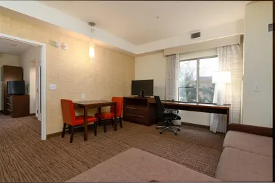 a hotel room with a desk with a computer and chairs at Residence Inn by Marriott Philadelphia Great Valley/Malvern in Malvern