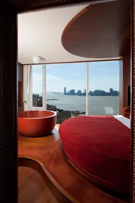 a bedroom with a tub and a bed and a window at The Standard, High Line New York in New York