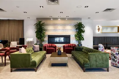 a living room with green couches and red chairs at DoubleTree by Hilton Fairfield Hotel & Suites in Fairfield