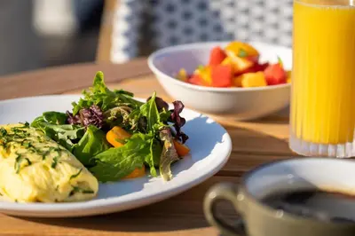 a plate of food with a salad and a bowl of fruit at DoubleTree by Hilton Fairfield Hotel & Suites in Fairfield