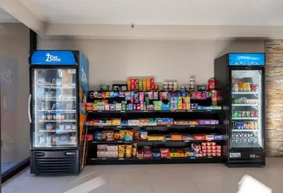 a store aisle with two refrigerators and food and drinks at Red Roof Inn Bordentown - McGuire AFB in Bordentown