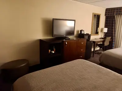 a hotel room with a television on a dresser with a desk at Quality Inn Horseheads in Horseheads