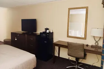 a hotel room with a bed and a desk with a television at Quality Inn Horseheads in Horseheads