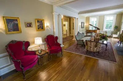 a living room with red chairs and a table at Hollinger House in Lancaster