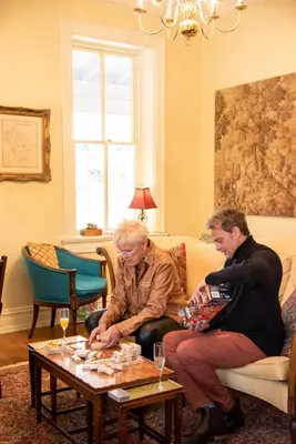 two people sitting on a couch in a living room at Hollinger House in Lancaster