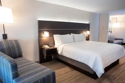 a hotel room with a large bed and a chair at Holiday Inn Express Hotel & Suites Chester by IHG in Chester