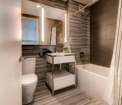 a bathroom with a toilet and a sink and a bath tub at Global Luxury Suites at Sky in New York