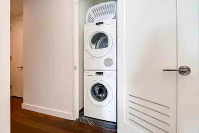 a washer and dryer in a white laundry room at Global Luxury Suites at Sky in New York