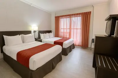 a hotel room with two beds and a television at Heritage Hotel New York City in New York