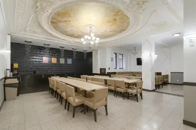 a dining room with tables and chairs and a ceiling at Heritage Hotel New York City in New York
