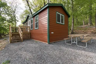 a tiny house with a porch and a bench at Spring Gulch Cottage 1 in Mount Airy