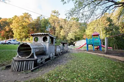 a small train sitting in a park with a playground at Spring Gulch Cottage 1 in Mount Airy