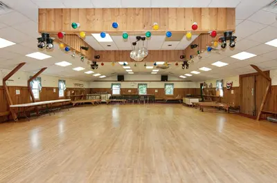 an empty dance hall with wooden floors and colorful balloons at Spring Gulch Country House 9 in Mount Airy