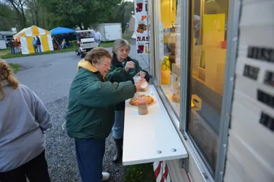 a man and woman buying food from a food truck at Spring Gulch Lodge 11 in Mount Airy