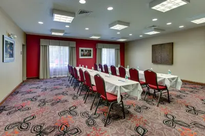 a conference room with a long table and red chairs at Holiday Inn Express Hotel & Suites Lancaster-Lititz by IHG in Lititz