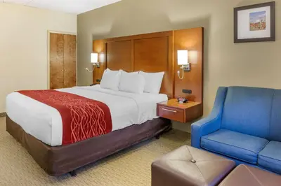 a hotel room with a bed and a blue chair at Comfort Inn Lancaster at Rockvale in Lancaster