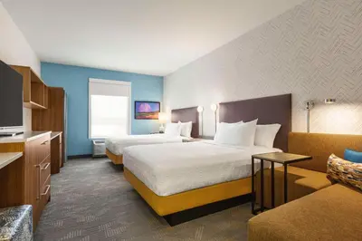 a hotel room with two beds and a couch at Home2 Suites By Hilton York in York