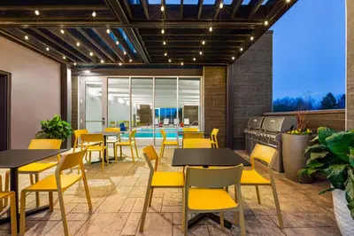 a restaurant with tables and chairs and a pool at Home2 Suites By Hilton York in York