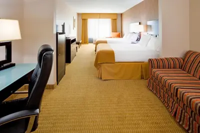 a hotel room with two beds and a couch at Holiday Inn Express Hotel & Suites Lebanon by IHG in Lebanon