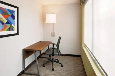 a desk and chair in a room with a painting at Holiday Inn Express Harrisburg East by IHG in Harrisburg