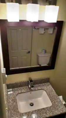 a bathroom with a sink and a mirror and a toilet at Gene's Motel in Cinnaminson