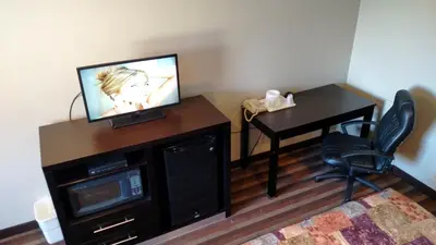 a room with a television and a desk with a chair at Gene's Motel in Cinnaminson