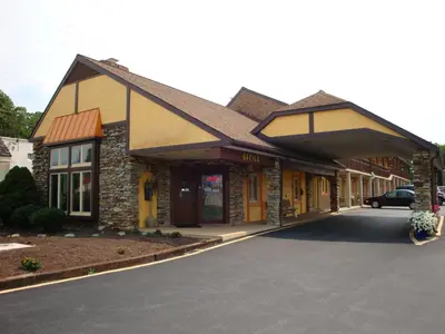 a building with a car parked in front of it at Soudersburg Inn & Suites Lancaster in Ronks