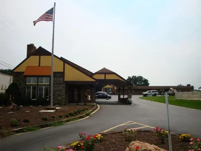 a house with an american flag in front of it at Soudersburg Inn & Suites Lancaster in Ronks