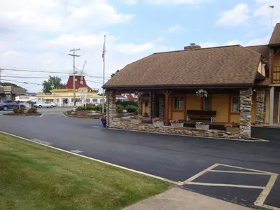 a building with a bench on the side of a street at Soudersburg Inn & Suites Lancaster in Ronks